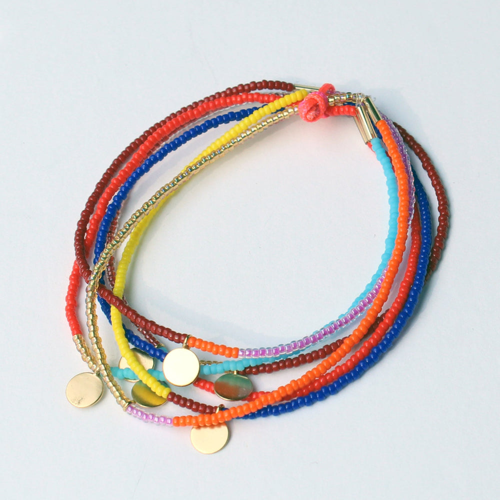 Stack of colorful beaded bracelets on a light gray background