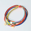 Stack of colorful beaded bracelets on a light gray background